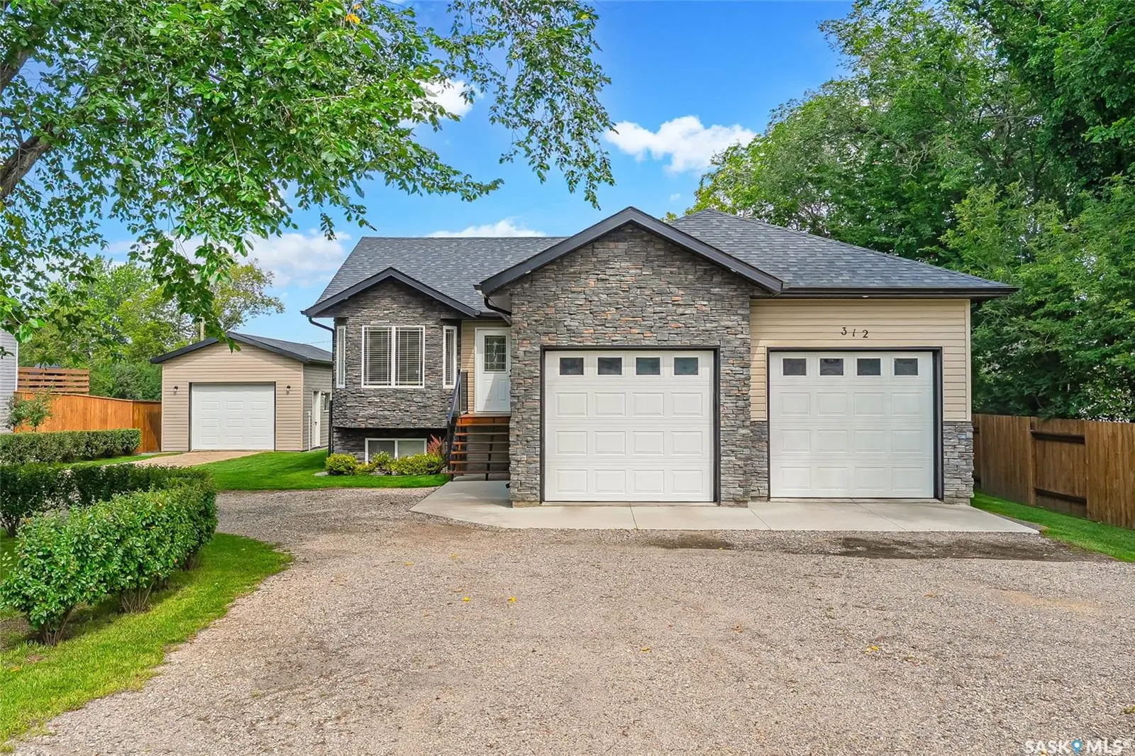 Exterior photo of 312 2nd Avenue S, Hepburn SK showcasing landscaped lot and executive bungalow.